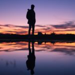 Deze afbeelding illustreert een man die zijn eigen reflectie aanschouwt als ware het een kijkje in de spiegel